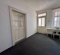 Innenraum eines Einfamilienhauses mit Teppich, Schreibtisch und Stuhl, weiße Wände.