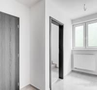 Innenraum eines Einfamilienhauses mit weißen Wänden, Kunststofffenstern und Türen mit Holzdekor.