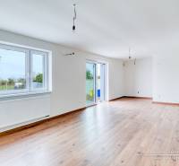 Geräumiges Wohnzimmer in einem Einfamilienhaus mit Holzboden und großen Fenstern.