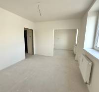 Helles Zimmer, großes Fenster, weiße Wände und Heizkörper in einer 2-Zimmer-Wohnung.