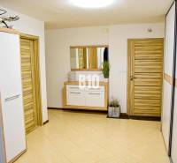 Innenraum eines Einfamilienhauses mit Holztüren, Spiegel und Fliesen.