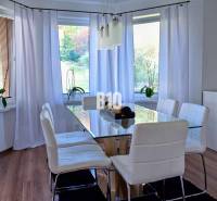 Essbereich mit hellem Interieur, Glastisch und weißen Stühlen.