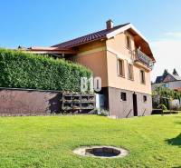 Ein Einfamilienhaus in Čadca mit grünem Hof, lebender Hecke und einer gemütlichen Terrasse.