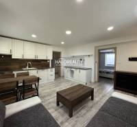 Wohnzimmer mit Küchenzeile in einer 3-Zimmer-Wohnung, enthält Holzelemente und Möbel.