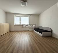 Ein Zimmer mit Holzboden, einem Sofa und einer Kommode in einer 3-Zimmer-Wohnung.