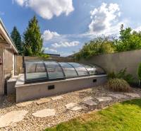 Der Garten des Einfamilienhauses in der Jazdecká-Straße in Trnava mit überdachtem Pool und Grünflächen.