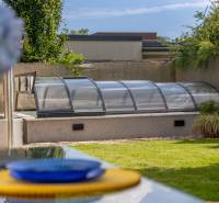 Garten mit einem Pool, der von einem verglasten Unterstand in einer 4-Zimmer-Wohnung in der Jazdecká-Straße in Trnava überdacht ist.