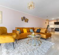 Wohnzimmer in einer 4-Zimmer-Wohnung mit einem bequemen Sofa und einem Boden in Holzoptik.