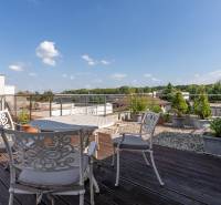 Die Terrasse des Einfamilienhauses in der Jazdecká-Straße in Trnava mit Blumenkästen und Sitzgelegenheiten.