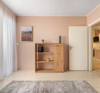 Innenraum eines Einfamilienhauses mit Holzboden, Schrank und Vorhängen.