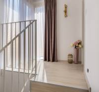 Innenraum eines Einfamilienhauses mit Holzboden, Vorhängen und dekorativer Beleuchtung.