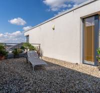 Die Terrasse des Einfamilienhauses in der Jazdecká-Straße in Trnava mit Grünflächen und einer Liege.
