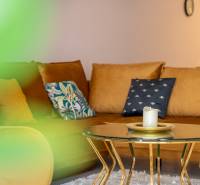 Einfamilienhaus mit Sofa, Tisch mit Kerze und dekorativen Kissen.