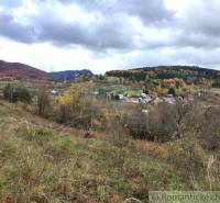 Herbstlandschaft in Hlboké nad Váhom mit einem bunten Wald und einem Dorf im Tal.