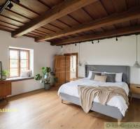 Schlafzimmer in einem Einfamilienhaus mit Holzboden, Pflanzen und einem großen Bett.