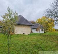 Ein Einfamilienhaus in Senohrad, umgeben von Bäumen und einem grasbewachsenen Garten im Herbst.
