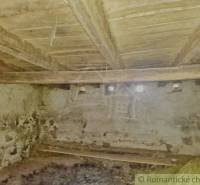 Innenraum eines Einfamilienhauses mit Holzbalkendecke und Steinwänden.