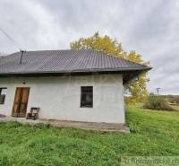 Ein Einfamilienhaus in Senohrad mit einer einfachen Fassade, umgeben von Natur und einem grasbewachsenen Grundstück.
