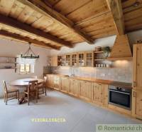 Eine Küche in einem Einfamilienhaus mit einer mit Holz verkleideten Decke, einem Tisch und Schränken.