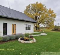 Ein Einfamilienhaus in Senohrad mit weißer Fassade, gepflegtem Garten und einem großen Baum.