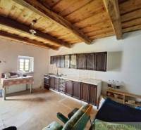 Eine Küche in einem Einfamilienhaus mit einer Holzdecke, Schränken und einem Boden mit Holzdekor.