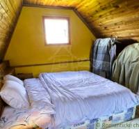 Ein Schlafzimmer in einer Hütte mit einem Bett, einem Dachfenster und Holzelementen.