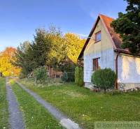 Eine Hütte in Sološnica an der Straße, umgeben von Bäumen und Rasen im Herbst.