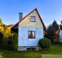 Eine Hütte in Sološnica, umgeben von Grün, mit blauer Putzfassade und schrägem Dach.