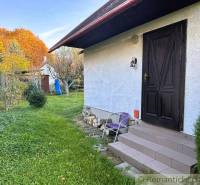 Ein Haus in Sološnica mit Rasen und Bäumen in einer farbenfrohen Herbstlandschaft.