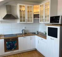 Küche in einer 3-Zimmer-Wohnung mit Holzboden, weißen Schränken und Stauraum.