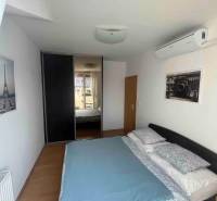 Schlafzimmer in einer 3-Zimmer-Wohnung mit Bett, Klimaanlage und Einbauschrank.