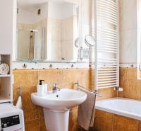 Badezimmer in einer 3-Zimmer-Wohnung mit Waschbecken, Badewanne, Waschmaschine und Handtuchhalter.