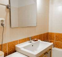 Badezimmer mit Spiegel und Waschbecken in einer 2-Zimmer-Wohnung.