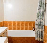 Badezimmer mit Badewanne und Keramikfliesen in einer 2-Zimmer-Wohnung.