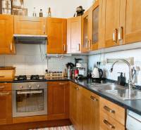 Küche mit Holzschränken und Geräten in einer 2-Zimmer-Wohnung.