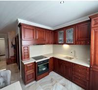 Küche mit dunklen Holzschränken und Holzboden in einem Einfamilienhaus.