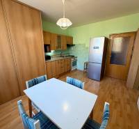 Küche in einer Einzimmerwohnung mit Holzboden und Esstisch.