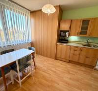 Küche in einer Einzimmerwohnung mit Holzboden und Esstisch.