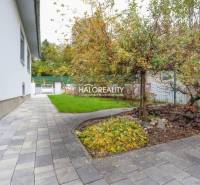 Pflasterung und Garten rund um das Einfamilienhaus in Domaniža, mit üppigem Grün.