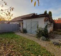 Ein Einfamilienhaus in Dlhá Ves mit einem Hof, einer Rasenfläche und einer Garage, umgeben von einem Zaun.