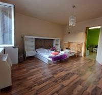 Kinderzimmer in einem Einfamilienhaus mit Bett, Kinderbett und Boden mit Holzdekor.