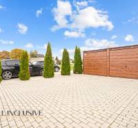Parkplatz bei einer 3-Zimmer-Wohnung in Gabčíkovo, mit Autos und einer Holzgarge.