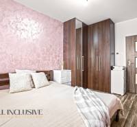 Schlafzimmer mit Bett, Schrank und Holzboden in einer 3-Zimmer-Wohnung.