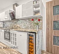 Küche in einer 3-Zimmer-Wohnung mit Holzboden und Marmor-Arbeitsplatte.