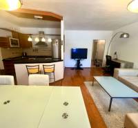 Wohnzimmer in einer 3-Zimmer-Wohnung mit Küche, Esstisch und bequemer Sitzgelegenheit.