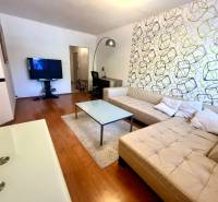 Wohnzimmer mit beigem Sofa und Fernseher in einer 3-Zimmer-Wohnung.