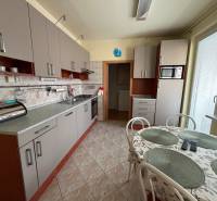 Eine Küche mit hellgrauen Schränken in einer 3-Zimmer-Wohnung, ergänzt durch einen Esstisch.