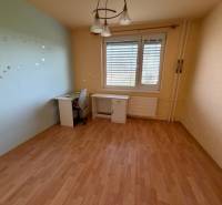 Ein Zimmer in einer 3-Zimmer-Wohnung mit einem Boden in Holzoptik und einem Schreibtisch.