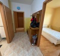 Flur in einer 3-Zimmer-Wohnung mit Fliesenboden, Zugang zum Badezimmer und Schlafzimmer mit Holzboden-Dekor.