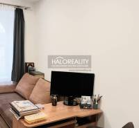 Wohnzimmer mit Sofa, Tisch und Holzboden in einer 3-Zimmer-Wohnung.